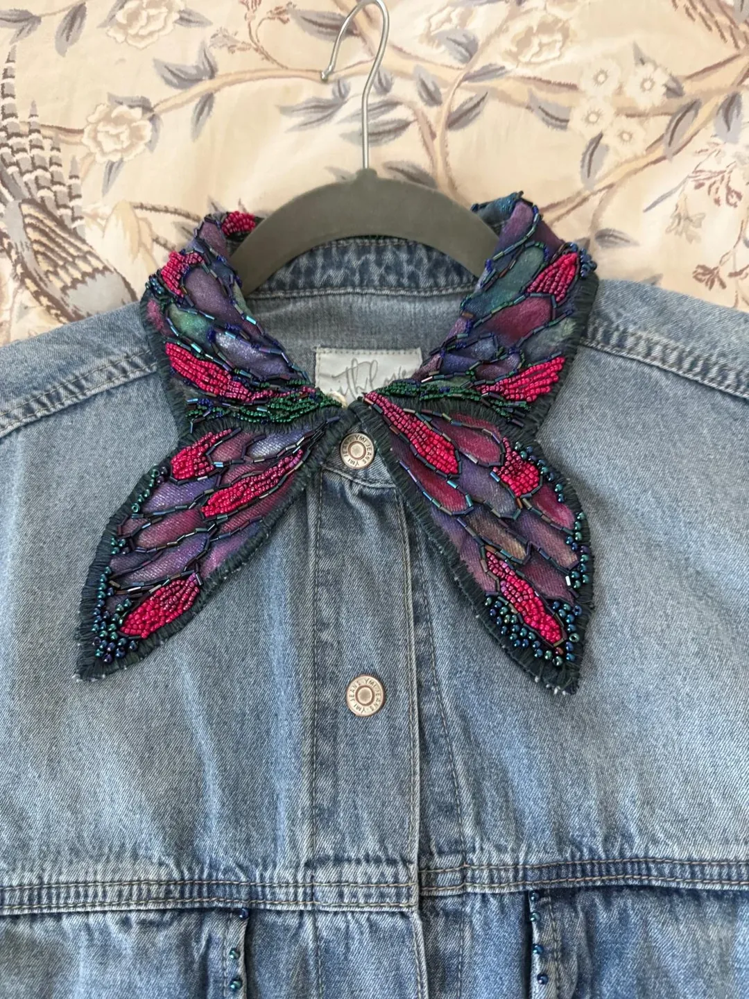 Pink butterfly embroidery on a denim shirt collar