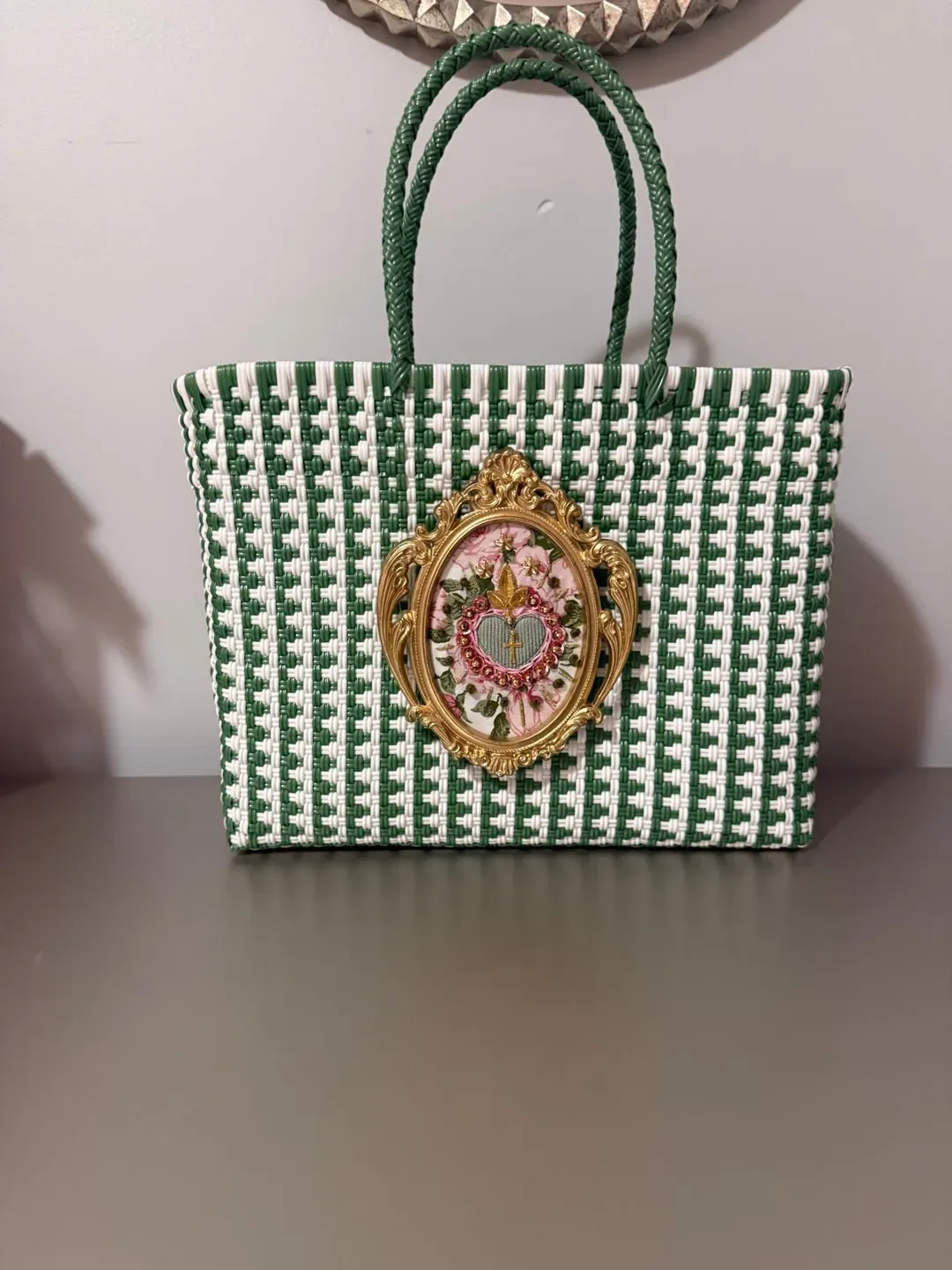 Green and cream woven handbag with a decorative heart